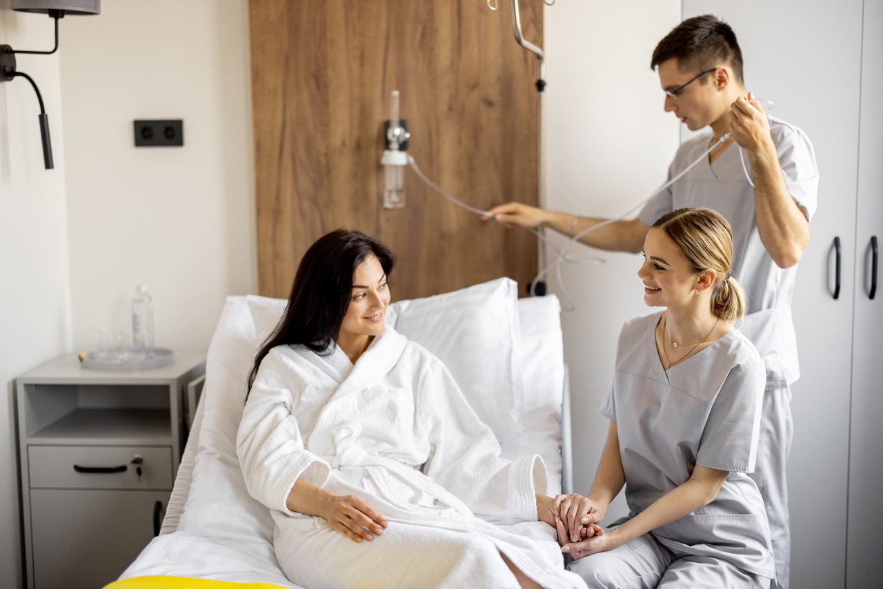 Pielęgniarze i pacjentka po zabiegu chirurgicznych – zdjęcie ilustrujące tekst o tym, jak tlenoterapia wspiera regenerację po zabiegu chirurgicznym.